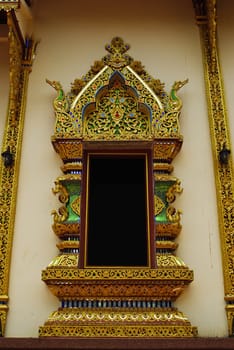 Ancient Golden carving wooden window of Thai temple in Thailand.