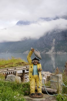 a wooden sculpture of fisherman is in camping of the quiet Norwegian bay