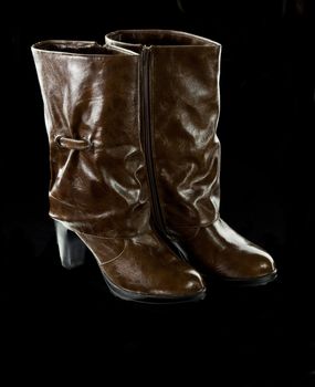 high brown female boots on the black background