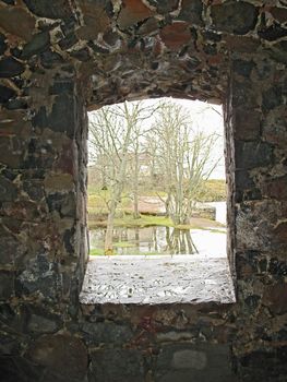 View from window in the castle wall to the spring landscape.