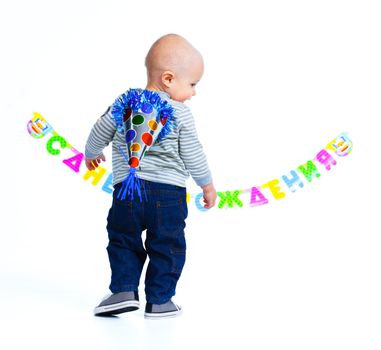Cute funny little boy in first birthday with colored balloons. In the studio