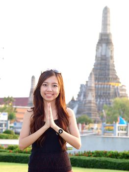 Attractive asian woman greeting with Temple of Dawn Wat Arun background