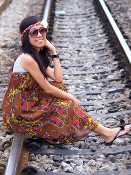 Young pretty Asian girl sitting on railway