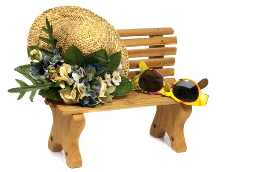 brown wooden stool with old hat and yellow children sunglasses