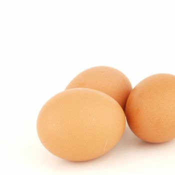 Three brown eggs isolated on white background