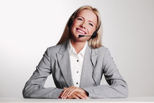 business woman in a headset on a gray background
