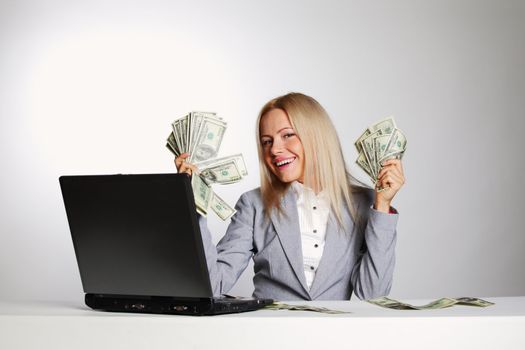 business woman working on laptop dollar in hands