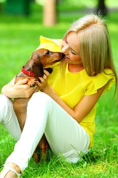 woman dachshund in her arms on grass