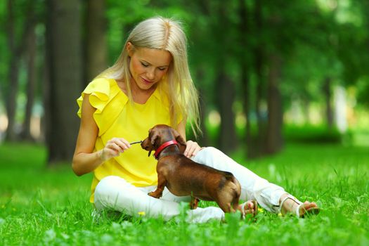woman dachshund in her arms on grass