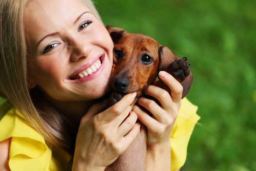 woman dachshund in her arms on grass