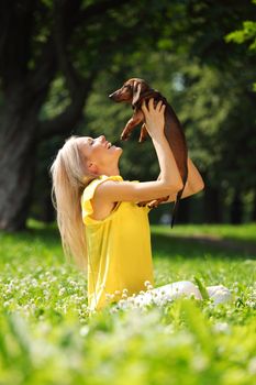 woman dachshund in her arms on grass