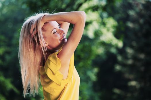 happy woman posing against a background of trees