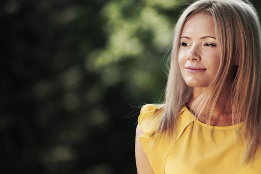 happy woman posing against a background of trees