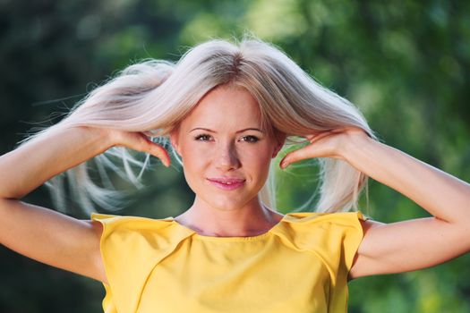 happy woman posing against a background of trees