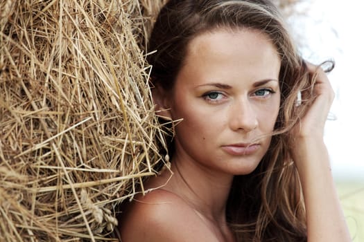 portrait of a girl next to haystack close