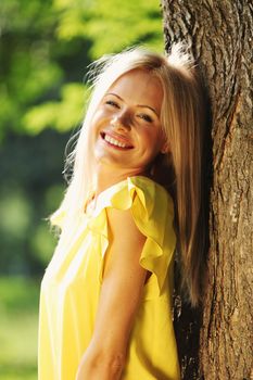 happy woman posing against a background of trees