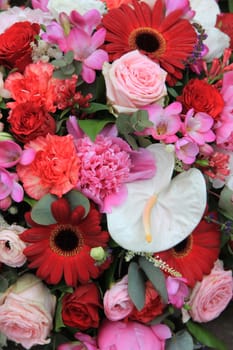 Flower arrangement with various flowers in different shades of red  and pink