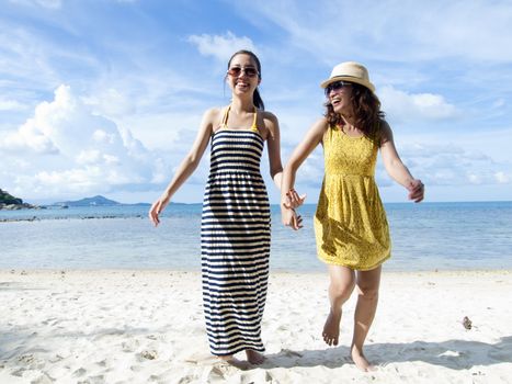 woman happy together on sand beach with blue sky background