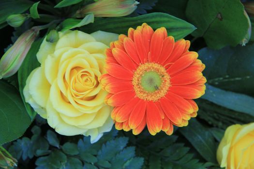 Close up of a yellow rose and orange gerbera
