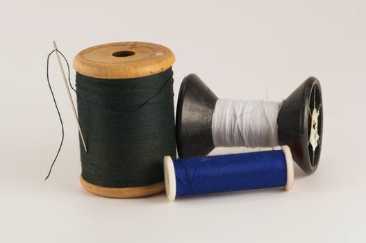 Spool of thread with needle  on white background