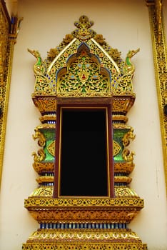 Ancient Golden carving wooden window of Thai temple in Thailand.