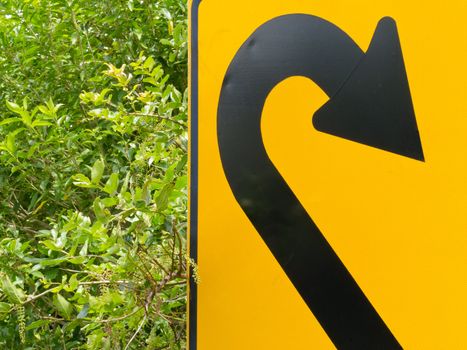 U-turn road sign and lush vegetation in a think green concept of environmental turn-around