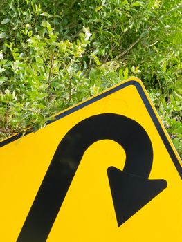 U-turn road sign and lush vegetation in a think green concept of environmental turn-around