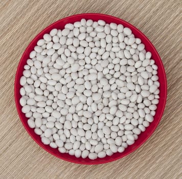 White beans in a round red bowl