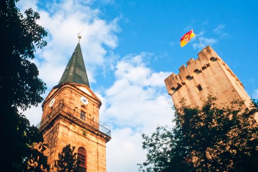 Historic church spire and city tower of Marktredwitz in Germany, Europe, flying a flag showing the city arms