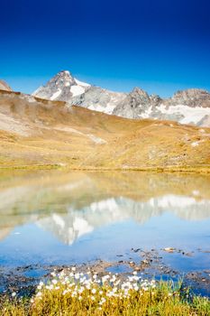 Snowy mountain of Grossglockner in National Park Hohe Tauern, European Alps, the highest peak of Austria, Europe, reflected on calm surface of alpine tarn