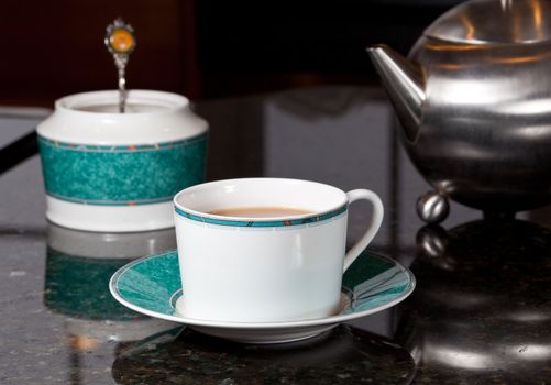 Fresh tea poured into white cup on marble kitchen worktop