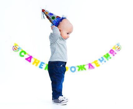 Cute funny little boy in first birthday with colored balloons. In the studio