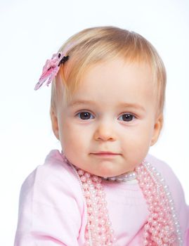 Portrait of an adorable baby girl wearing a pink with pearl necklace