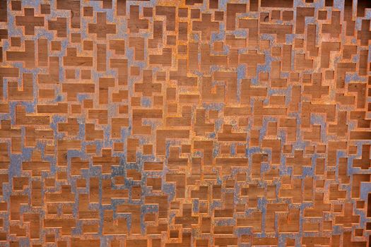 Rusted steel Grating with differing geometric hole and a wood background