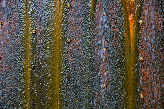 Water running over a rusty most covered steel plate