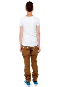 Rear view portrait of casual young boy isolated over white