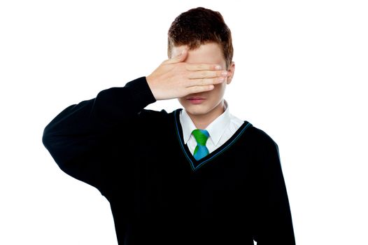 Boy hiding his face and eyes with hand. All on white background