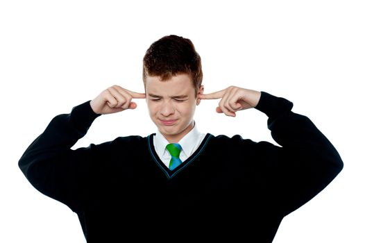 Loud noise becoming unbearable for kid. Boy with fingers on his ears