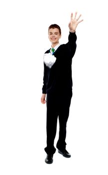 Cheerful young boy throwing paper isolated over white