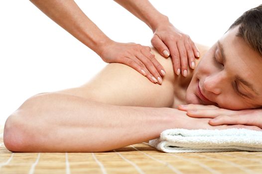 Handsome male getting spa massage relaxing against white background