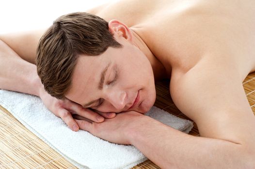 Young man relaxing at spa centre isolated on white background
