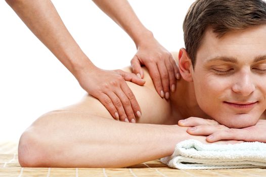 Attractive young man getting spa massage relaxing with his eyes closed