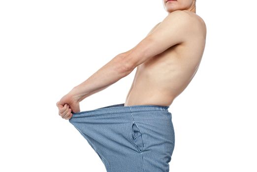 Cropped image of man wearing loose shorts and exposing it to camera