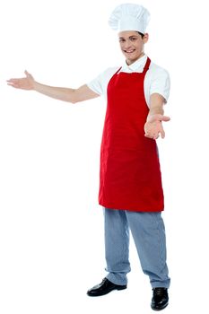 Portrait of a male chef in red uniform posing with his arms wide open