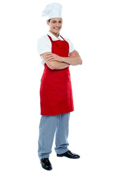 Full length shot of handsome smiling male chef posing with crossed arms