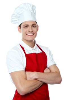 Smiling young chef posing with crossed arms against white background