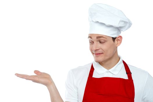 Chef looking at his hand. Offering cooked food. All on white background