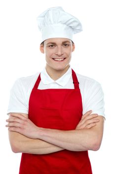 Portrait of confident male chef smiling with hands folded on white background