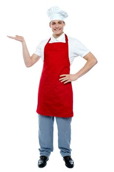 Full length portrait of handsome chef presenting copy space isolated against white background