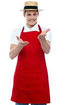 Handsome young male chef welcoming with smile over white background